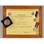 A LARGE GLAZED FRAME CONTAINING A CERTIFICATE AWARDED TO SP/4 MORRIE B. SINCLAIR, (U.S. Forces) by