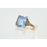 A GEM RING, designed as a central rectangular gem assessed as blue spinel, to the stepped shoulders,
