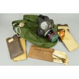 A GREEN HELMET BAG CONTAINING A WWII PERIOD GAS MASK, which is all complete, together with a