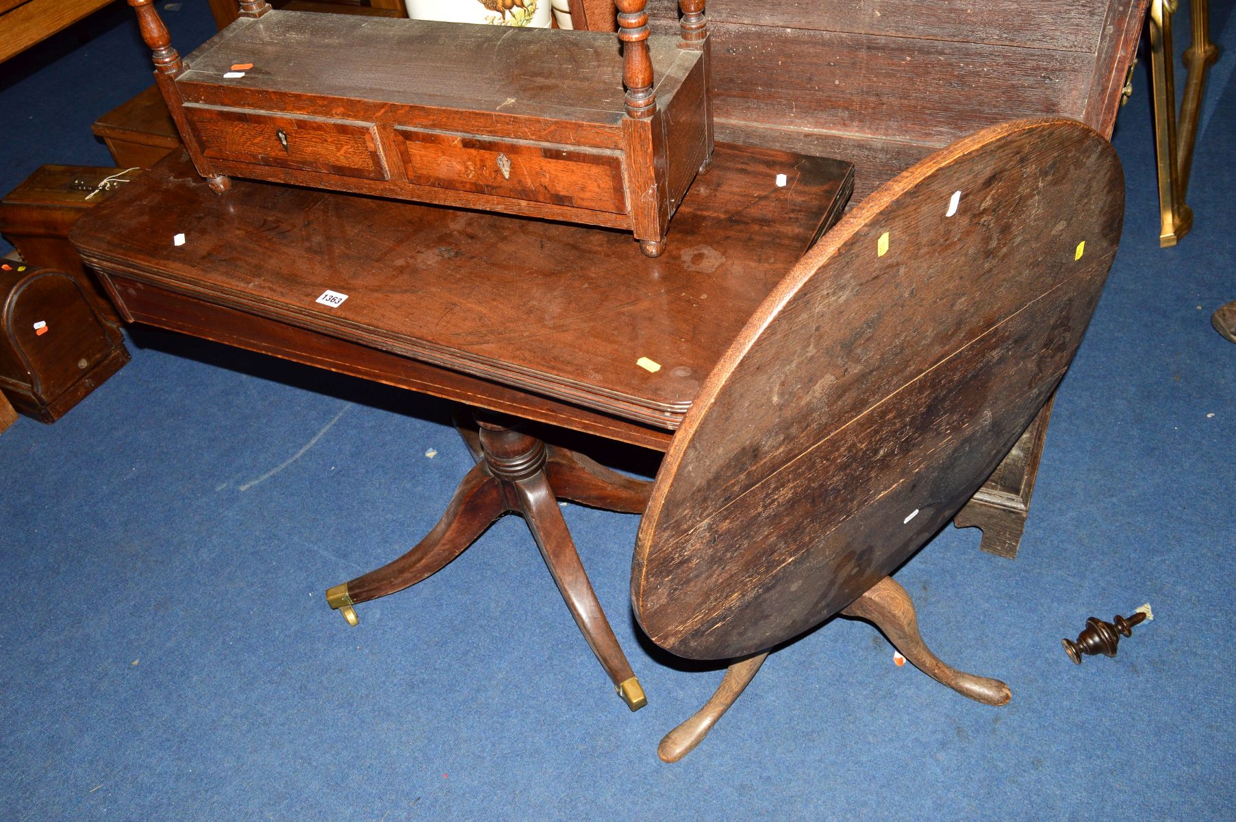 A GEORGIAN MAHOGANY FOLD OVER CARD TABLE, on a pedestal base with brass caps and casters, together