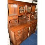 AN EARLY 20TH CENTURY OAK DRESSER, the top with double lead glazed doors above a bevelled edge
