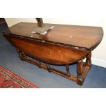 A REPRODUCTION GEORGE III STYLE OAK WAKE TABLE, the two rounded drop leaves to form an oval