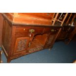 AN EDWARDIAN OAK SIDEBOARD with two drawers, width 152cm (missing top) together with an oak mirror