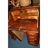AN EDWARDIAN OAK ROLL TOP DESK with four drawers, width 107cm x depth 82cm x height 129cm (locked