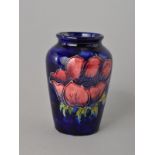 A SMALL MOORCROFT POTTERY VASE, Anemone pattern on blue ground, impressed painted backstamp and