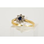 AN 18CT GOLD SAPPHIRE AND DIAMOND CLUSTER RING, the central circular sapphire within a brilliant cut