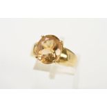 A 9CT GOLD CITRINE RING, designed as an oval citrine within a four claw setting, to the tapered