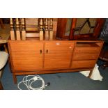 A GREAVES AND THOMAS TEAK SIDEBOARD flanked by three graduating drawers (fourth drawer missing),