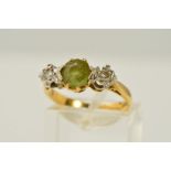 AN 18CT GOLD PERIDOT AND DIAMOND RING, designed as a central circular peridot with a single cut