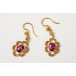 A PAIR OF EARLY 20TH CENTURY GOLD GARNET AND SPLIT PEARL EARRINGS, each designed as an oval garnet