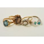 FOUR GEM SET RINGS, the first claw set with an oval smoky quartz, the second an oval opal cluster,