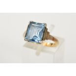 A GEM RING, designed as a central rectangular gem assessed as blue spinel, to the stepped shoulders,