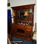 AN EDWARDIAN OAK MIRRORBACK SIDEBOARD, the top with triple bevelled edge mirrors, carved panels with