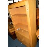 A MODERN LIGHT OAK OPEN BOOKCASE, above double cupboard doors, width 97cm x depth 34.5cm x height