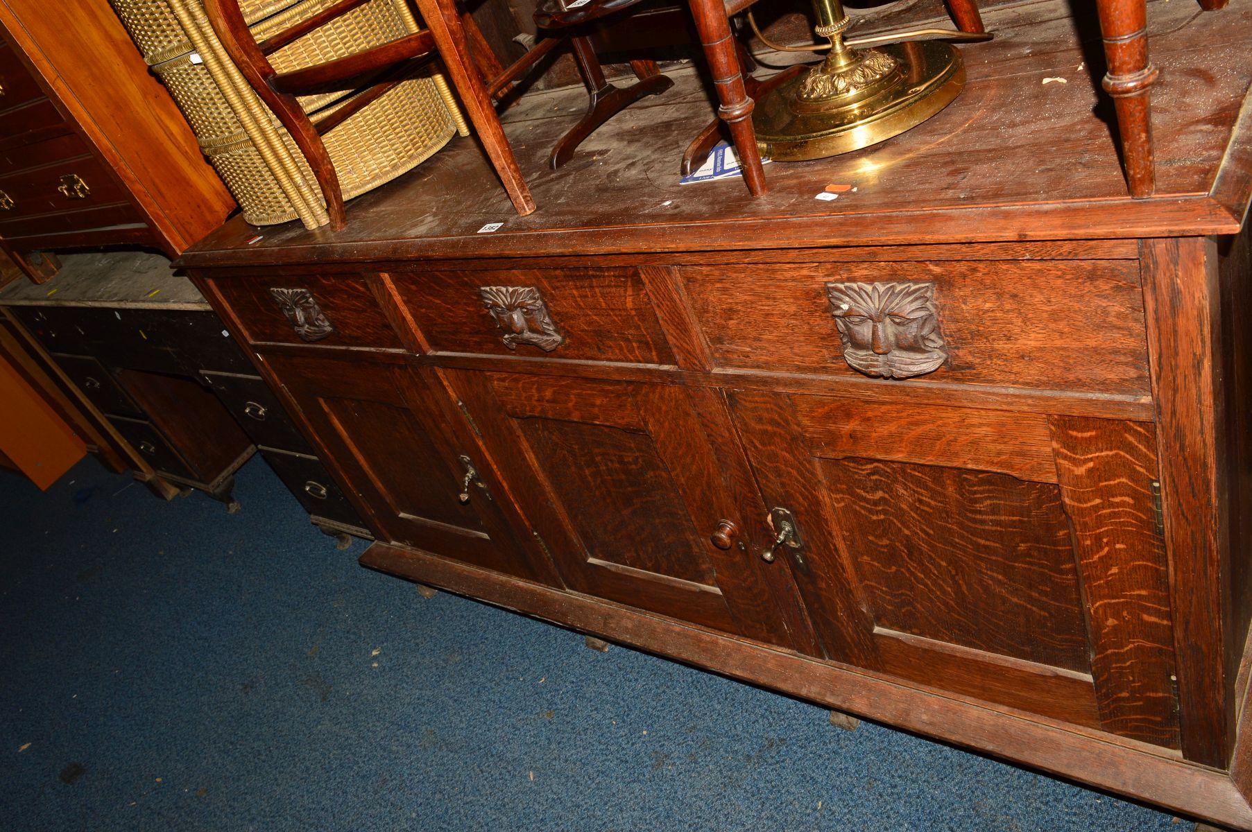 AN EARLY 20TH CENTURY OAK SIDEBOARD, with raised foliate carved back above three drawers, width