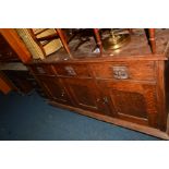 AN EARLY 20TH CENTURY OAK SIDEBOARD, with raised foliate carved back above three drawers, width