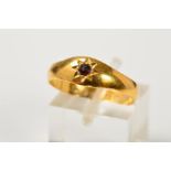 A LATE VICTORIAN 22CT GOLD RING, designed with a central circular red gem assessed as a garnet