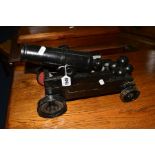 A BLACK PAINTED CAST IRON MINIATURE CANNON