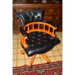 A REPRODUCTION FRUITWOOD FRAMED BLACK BUTTONED LEATHER SWIVEL OFFICE ARMCHAIR