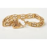 A 9CT GOLD BRACELET, designed as a fancy link, gate style bracelet, with a heart padlock clasp, with