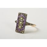 AN AMETHYST AND PERIDOT DRESS RING, the rectangular panel set with a vertical row of three peridots,