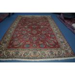 A 20TH CENTURY AXMINSTER WOOLLEN CARPET SQUARE, red ground with cream border and foliate design,