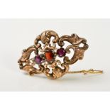 A LATE VICTORIAN GARNET BROOCH, of openwork scrolling design with a central garnet, flanked by