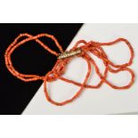 A CORAL BRACELET, designed as six rows of irregular shaped coral beads, to the base metal tube and