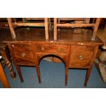 A GEORGIAN MAHOGANY AND BANDED SIDEBOARD with a central drawer flanked by cupboard doors on square