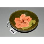 A MOORCROFT POTTERY FOOTED BOWL, 'Hibiscus' pattern on green ground and impressed marks to base,