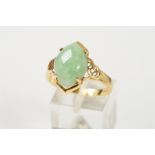 A 14CT GOLD JADE RING, designed as a marquise shape jade cabochon, to the openwork shoulders, with