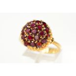 A GARNET AND RED PASTE DRESS RING, designed as circular garnets and red paste in a circular,