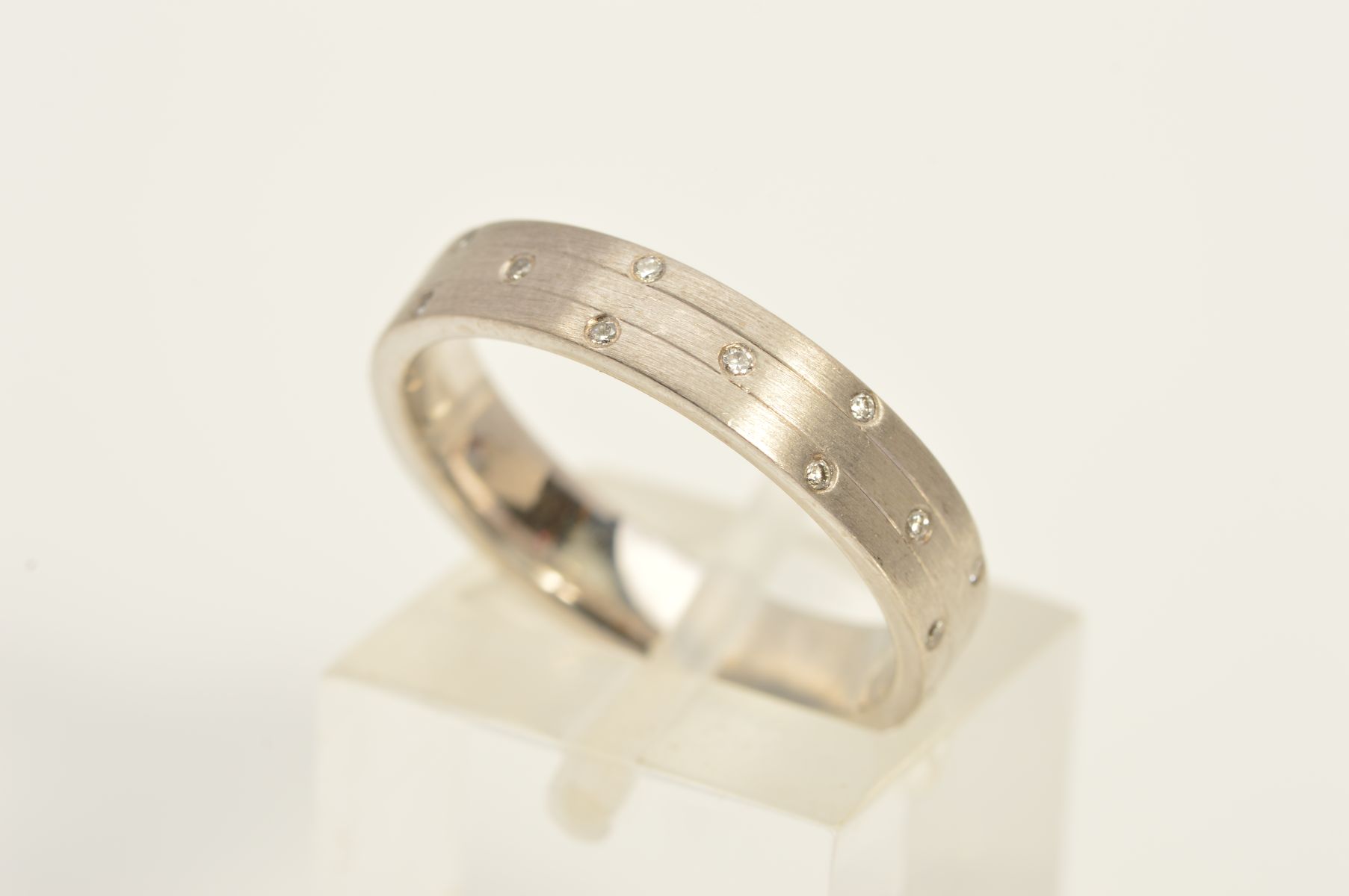 A MODERN 18CT WHITE GOLD AND DIAMOND SET WEDDING BAND, flat section measuring approximately 4.1mm in