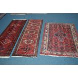 TWO SIMILAR WOOLLEN BOKARA STYLE RED GROUND CARPET RUNNERS, length 191cm, together with an tajabad