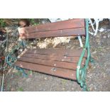 A WOODEN SLATTED AND CAST IRON GARDEN BENCH with scrolled ends