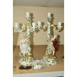 A PAIR OF CONTINENTAL PORCELAIN FIGURAL CANDELABRAS, encrusted with roses and foliage, height