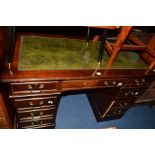 A REPRODUCTION MAHOGANY PEDESTAL DESK, green tooled leather inlayed top and eight various drawers,