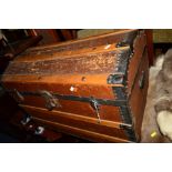 A VINTAGE WOODEN AND METAL BANDED DOMED TOPPED TRUNK