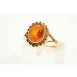 A 9CT GOLD CITRINE RING, designed as an oval citrine within a double rope twist surround to the