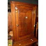 A GEORGIAN OAK PANELLED SINGLE DOOR HANGING CORNER CUPBOARD