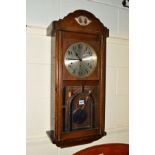 AN EARLY 20TH CENTURY OAK WALL CLOCK (winding key)