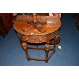 A REPRODUCTION OAK DEMI LUNE HALL TABLE, with carved fruiting vine and grape decoration to the