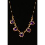 AN AMETHYST NECKLACE, designed as five oval amethysts each within an openwork textured scalloped