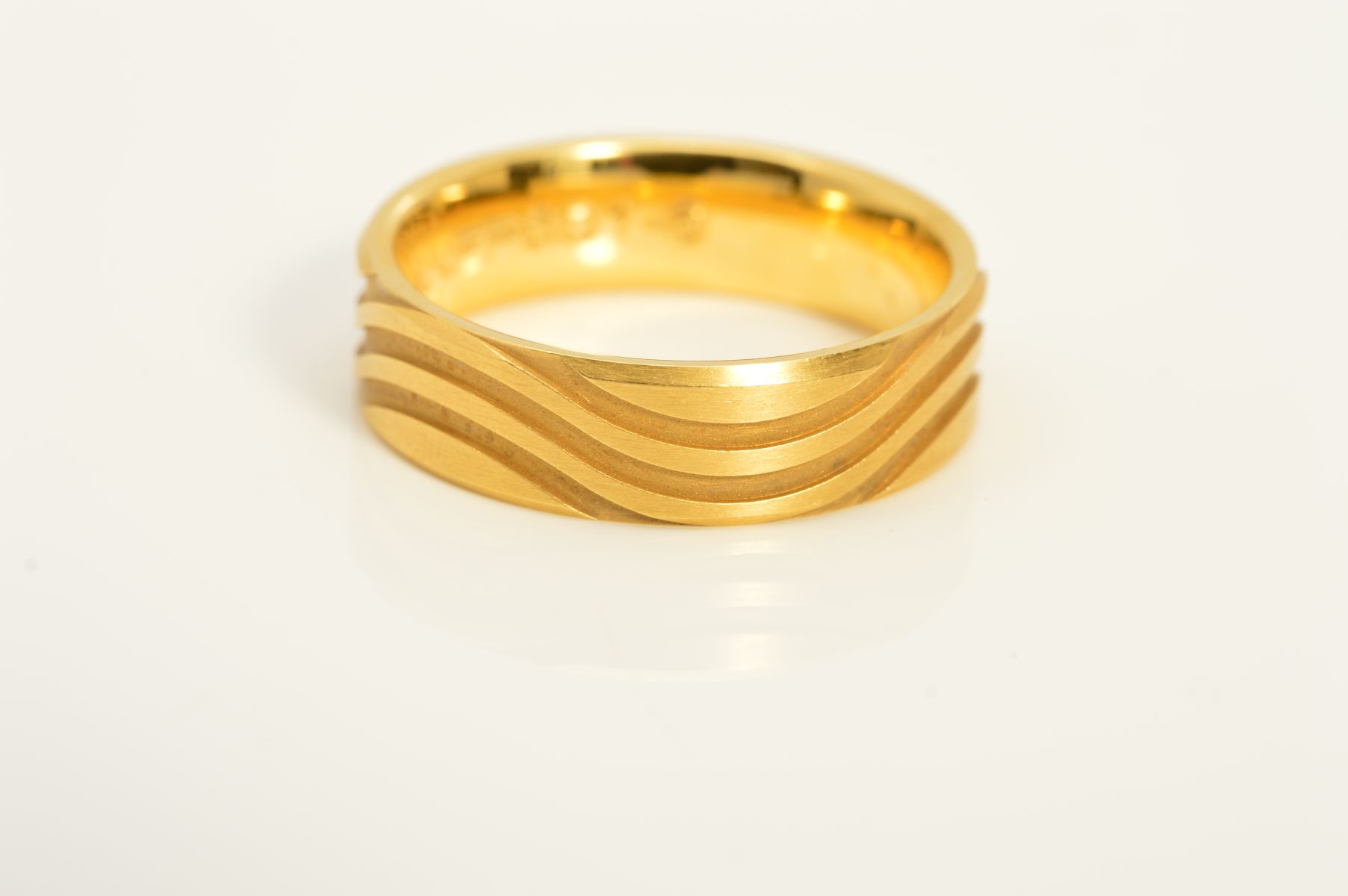 A MODERN 18CT GOLD WEDDING BAND, wave groove design in a satin finish, measuring approximately 6mm