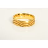 A MODERN 18CT GOLD WEDDING BAND, wave groove design in a satin finish, measuring approximately 6mm