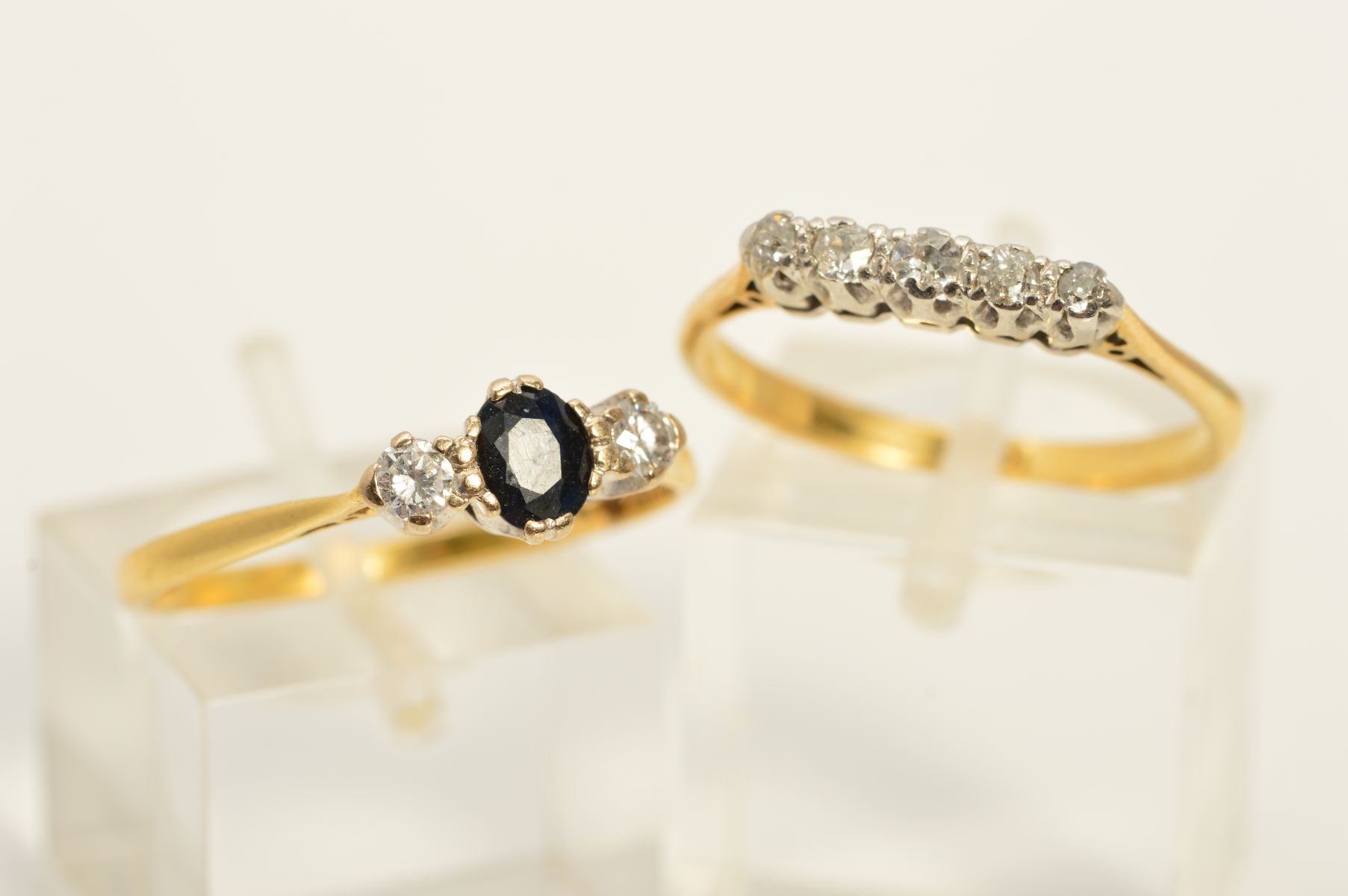 TWO GEM SET DIAMOND RINGS, to include a sapphire and diamond three stone ring, the central oval