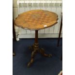 AN EDWARDIAN BURR WALNUT CHESS TABLE, wavy edge on a tulip upright and scrolled tripod legs