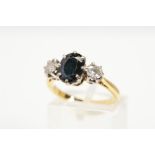 A SAPPHIRE AND DIAMOND RING, designed as a central oval sapphire with a brilliant cut diamond claw