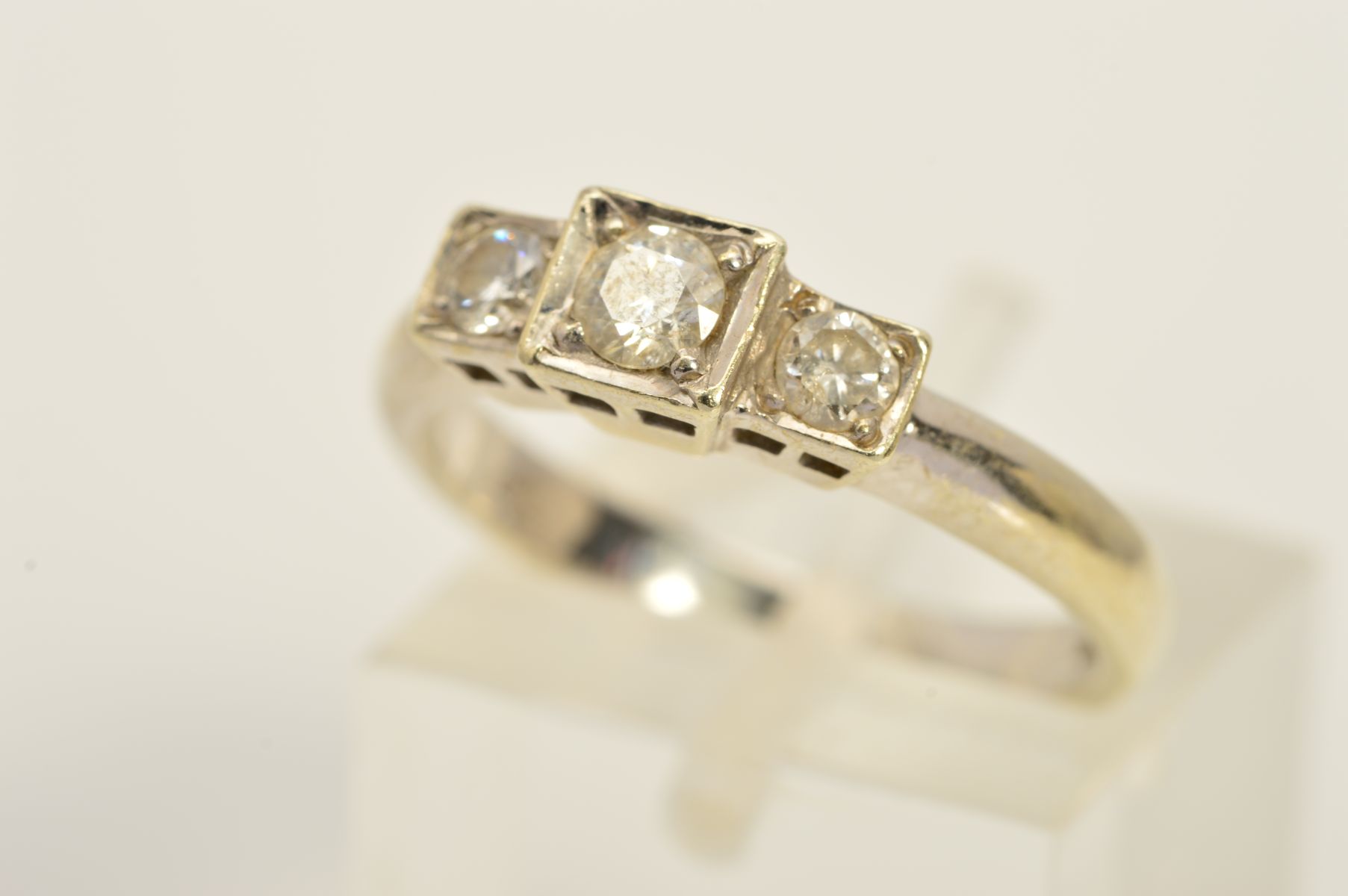 A MODERN 9CT WHITE GOLD THREE STONE DIAMOND RING, approximate modern round brilliant cut 0.33ct,