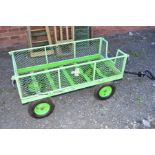 A GREEN ALUMINIUM PUSH ALONG FOUR WHEELED TROLLEY with hinged drop down sides